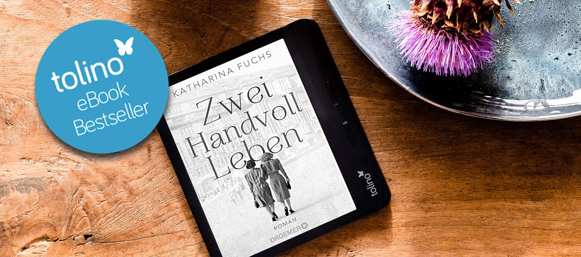 Ein tolino-eReader liegt auf Tisch und zeigt das Cover von "Zwei Handvoll Leben"