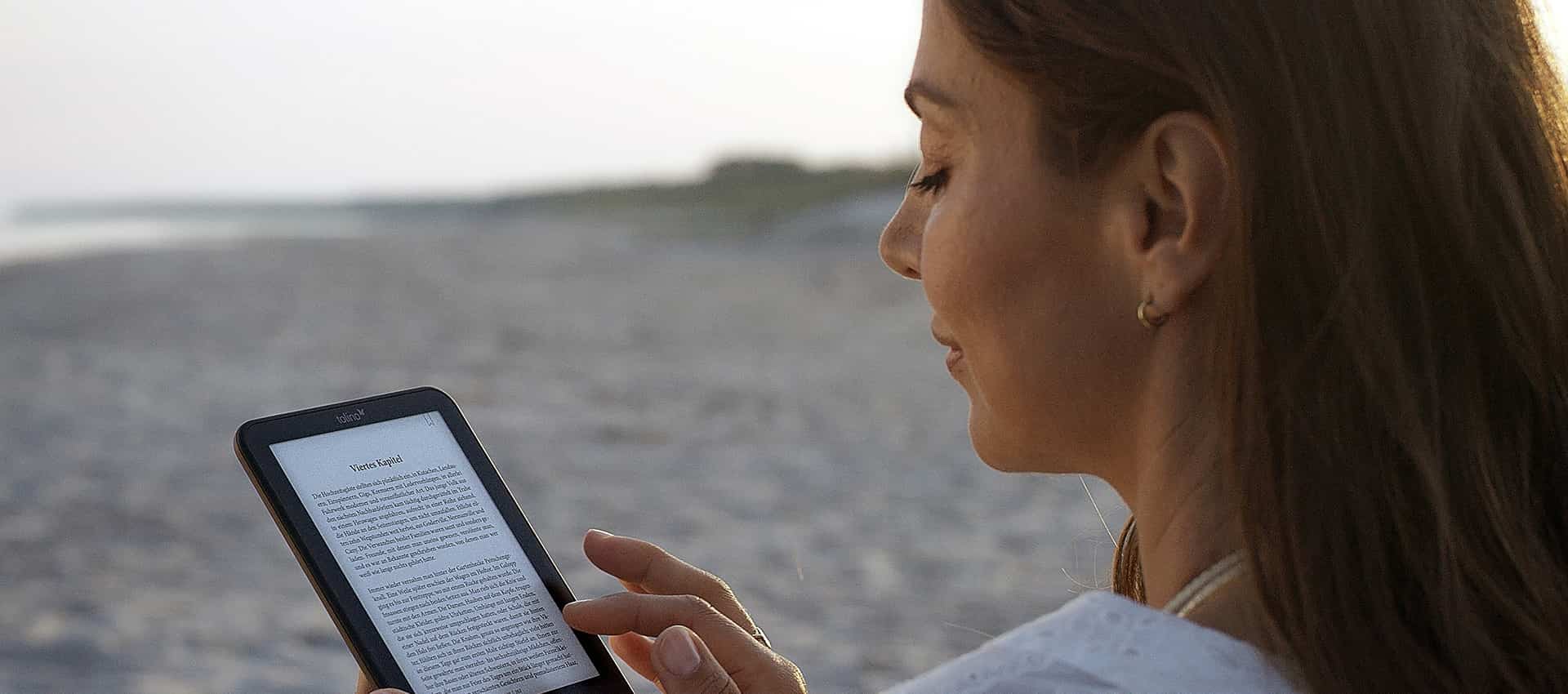Frau am Strand mit tolino-eReader.